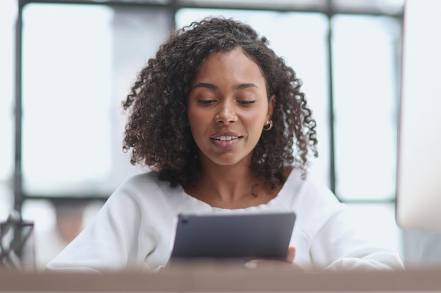 Heureuse femme d'affaires afro-américaine à l'aide d'une tablette numérique