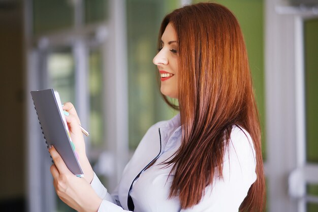 Heureuse femme d'affaires au bureau avec des documents