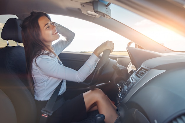 Heureuse femme d'affaires conduisant une voiture