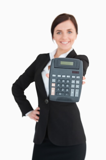 Heureuse femme d&#39;affaires en costume noir montrant une calculatrice