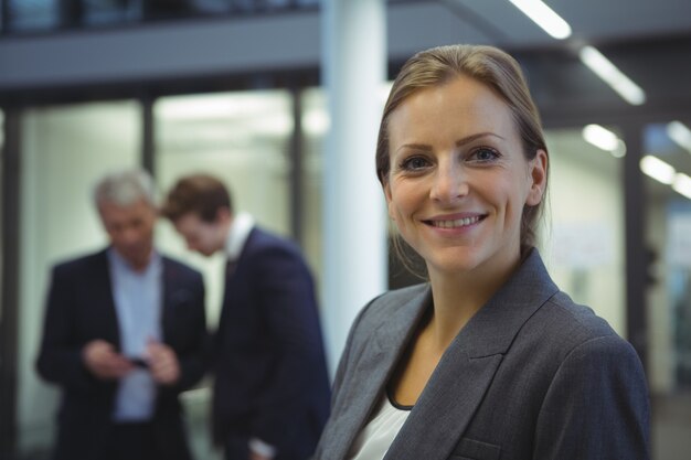 Heureuse femme d'affaires debout au bureau