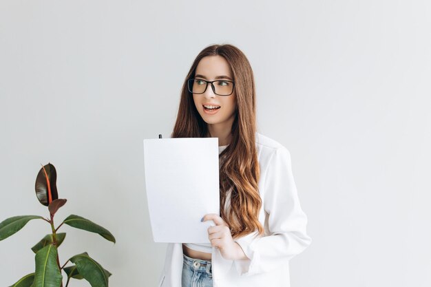 Heureuse femme d'affaires détenant des documents debout au bureau