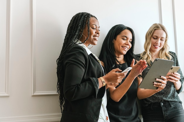 Heureuse femme d'affaires diversifiée à l'aide d'une tablette numérique