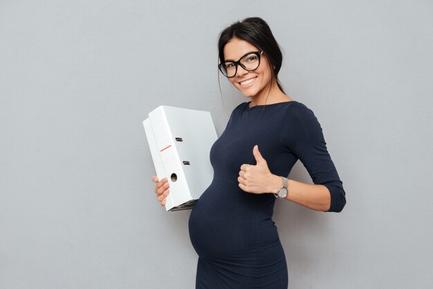 Heureuse femme d'affaires enceinte faire signe.