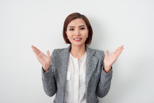 Heureuse femme d'affaires inspirée vêtue de vêtements de bureau à la recherche de ses mains sur blanc