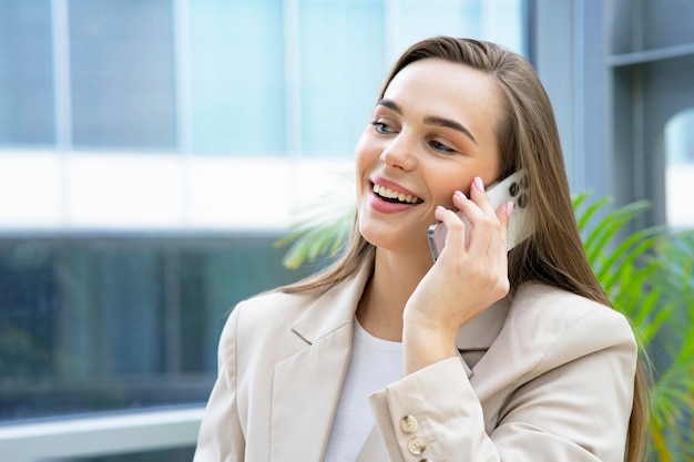 Heureuse femme d'affaires parlant sur smartphone mobile femme sourire communique au téléphone