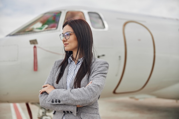 Heureuse femme d'affaires près de son jet privé