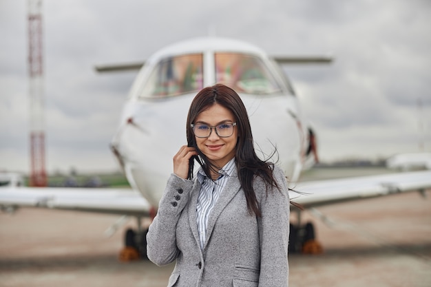 Photo heureuse femme d'affaires près de son jet privé