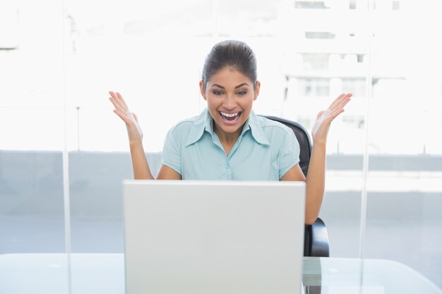 Heureuse femme d&#39;affaires en regardant portable dans le bureau