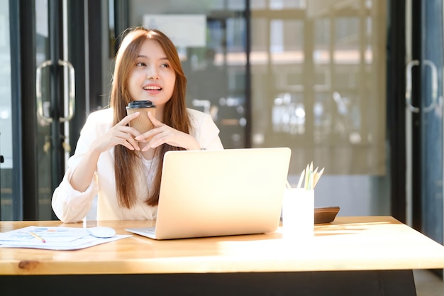 Heureuse femme d'affaires relaxante au bureau