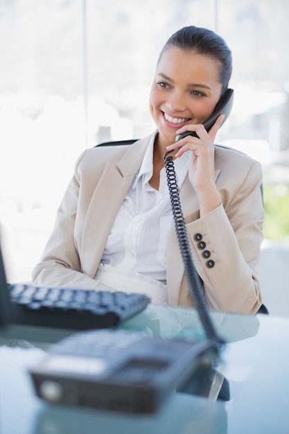 Heureuse femme d&#39;affaires répondant au téléphone