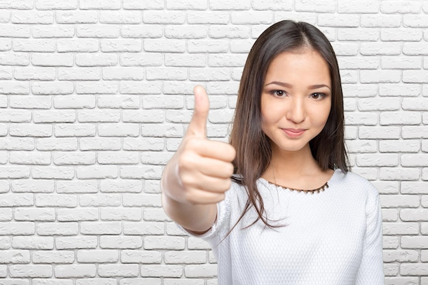 Heureuse femme d'affaires souriante avec le signe de la main ok