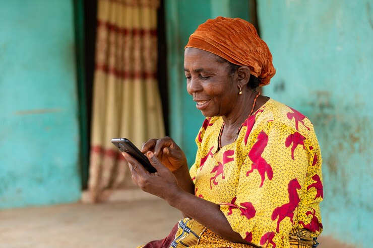 heureuse femme africaine âgée utilisant son téléphone portable