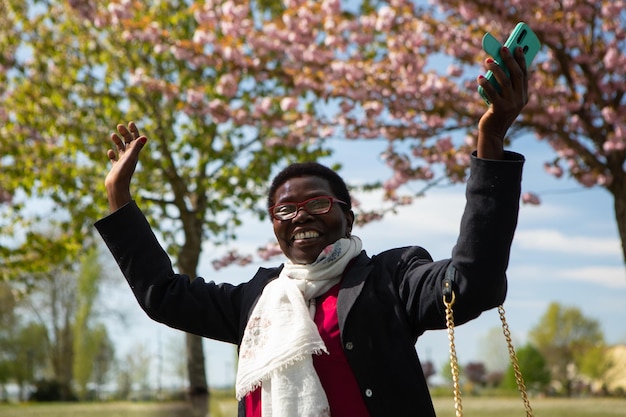 Heureuse femme africaine avec smartphone à la main Concept de liberté et d'émancipation