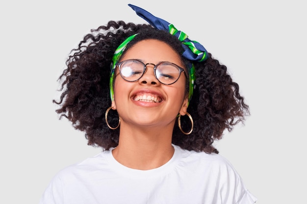 Heureuse femme afro-américaine souriant largement portant un t-shirt blanc et des lunettes transparentes passer du bon temps posant sur fond de studio blanc Personnes succès émotions et concept de bonheur