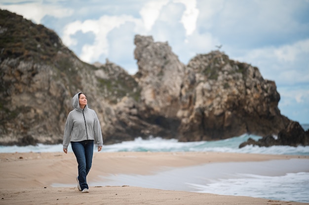 Heureuse femme d'âge moyen marchant sur la plage