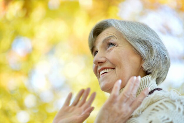 Heureuse femme âgée bénéficiant d'un parc en automne