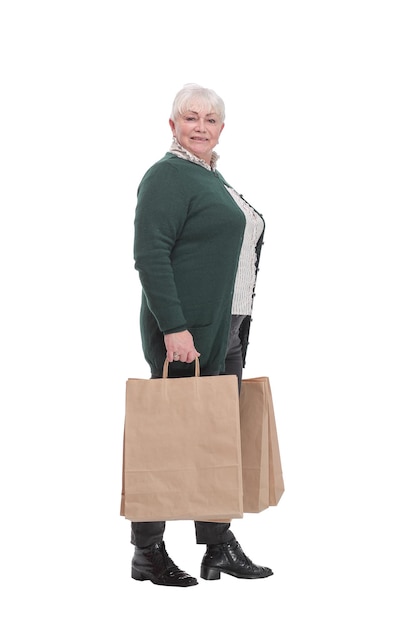 Heureuse femme âgée tendant les mains avec des sacs à provisions et souriant tout en se tenant isolé sur fond blanc. J'adore le shopping!
