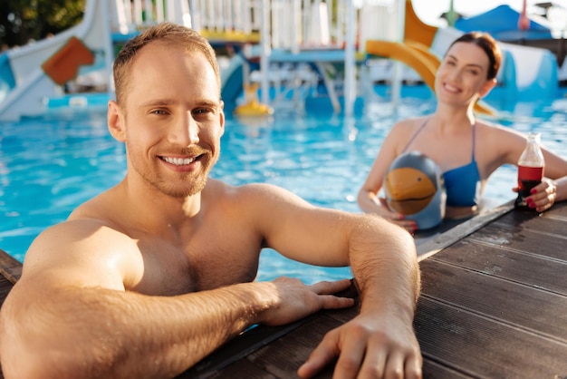 Heureuse femme aimante passer du temps avec son mari près de la piscine du complexe