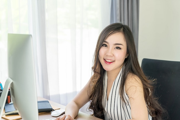 heureuse femme asiatique au bureau