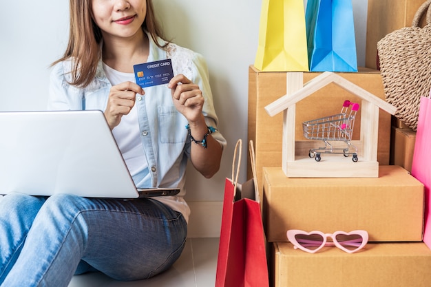 Heureuse Femme Asiatique Avec Des Sacs à Provisions Colorés Et Des Boîtes En Carton à La Maison