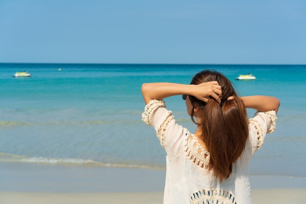 Heureuse femme asiatique voyageur profiter sur une plage tropicale en vacances. Concept d'été sur la plage.