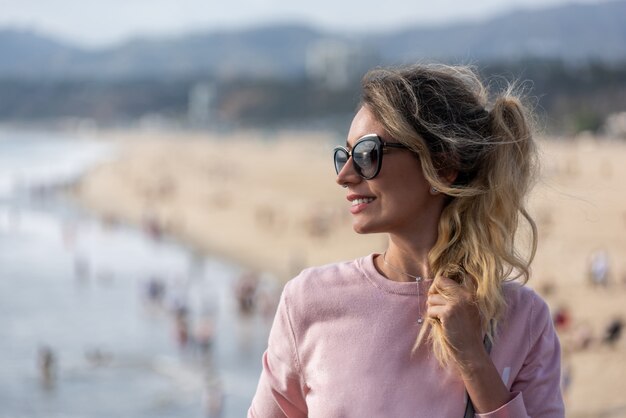 Heureuse femme blonde à la plage de Los Angeles