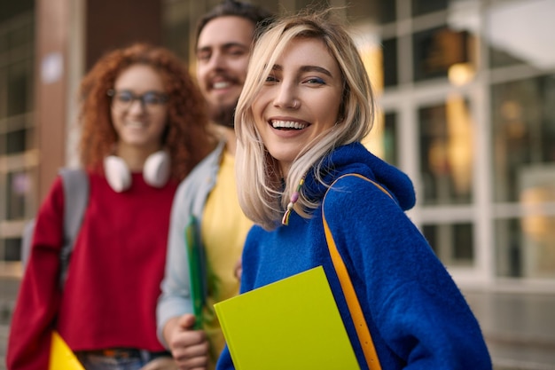 Heureuse femme blonde près de ses camarades de classe