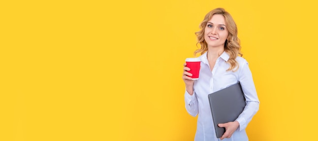 Heureuse femme blonde avec une tasse de café et un pc sur fond jaune Bannière de portrait de visage isolé de femme avec espace de copie maquette