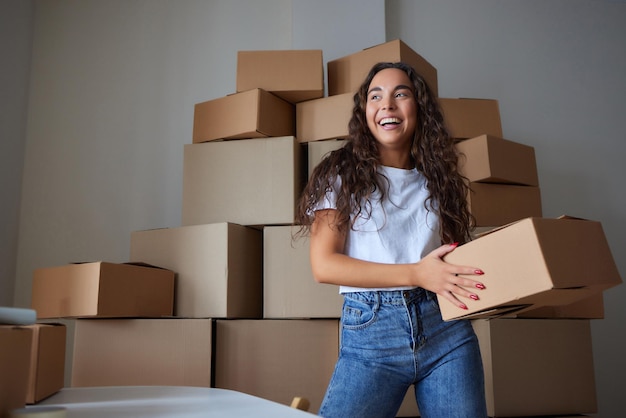 Heureuse femme déballant le conteneur à la maison ouvrant la boîte en carton regardant à l'intérieur de l'emballage Souriant client satisfait recevant le colis du service de livraison de commande achat de déballage