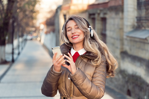 Heureuse femme écoutant de la musique sur un casque sans fil