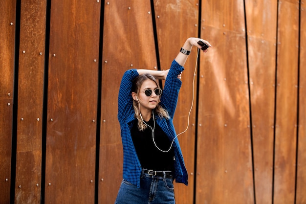 Photo heureuse femme écoutant de la musique avec des écouteurs