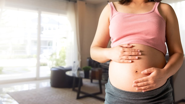 Heureuse femme enceinte avec bébé dans le ventre de femme enceinte