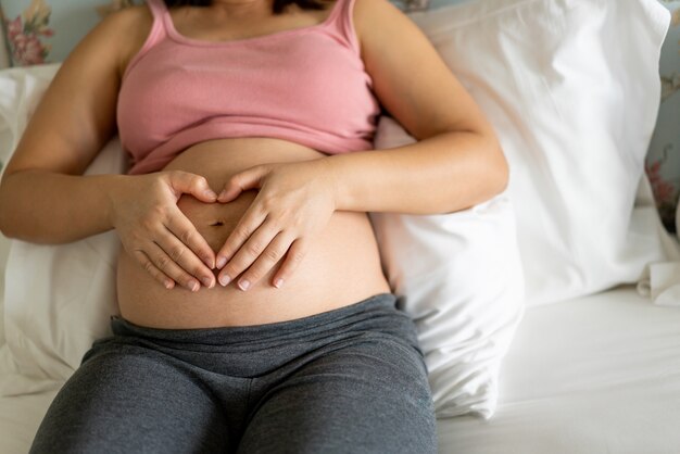 Heureuse femme enceinte et bébé qui attend.