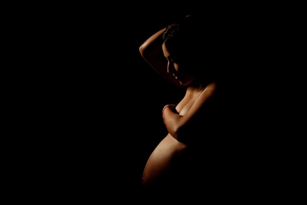 Heureuse femme enceinte dans le noir