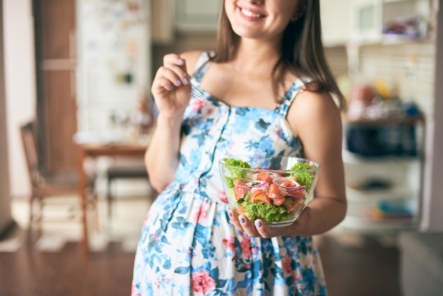 Heureuse femme enceinte gardant la plaque avec des légumes