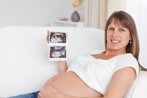 Heureuse femme enceinte montrant l&#39;échographie de son bébé