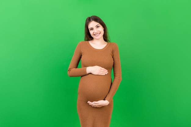 Heureuse femme enceinte touchant son abdomen sur fond coloré Future mère attendant un bébé Espace de copie