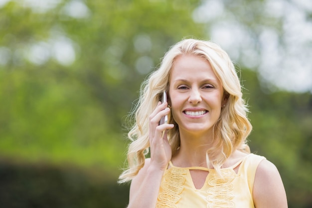 Heureuse femme faisant un appel téléphonique à l&#39;extérieur