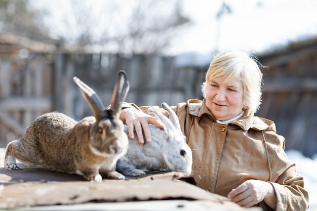 Heureuse femme et ferme de lapin. Bétail domestique