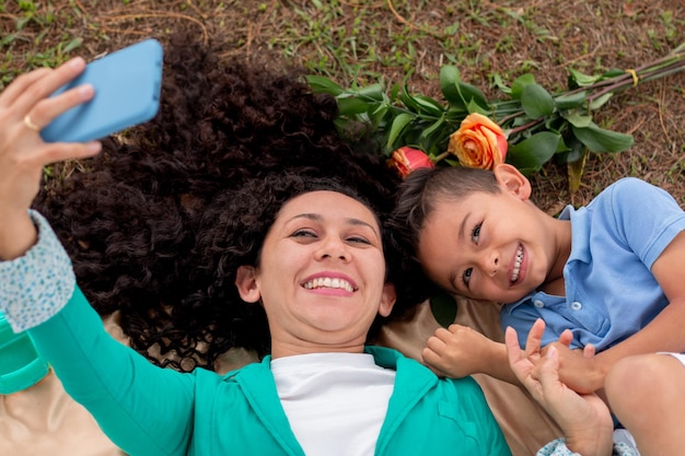 Heureuse femme et fils prenant un selfie sur une feuille tout en célébrant