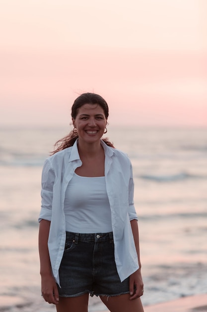 Heureuse femme insouciante profitant du beau coucher de soleil sur la plage. Mise au point sélective. Photo de haute qualité