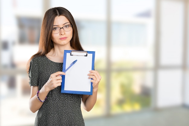 Heureuse femme jeune belle souriante avec le presse-papier