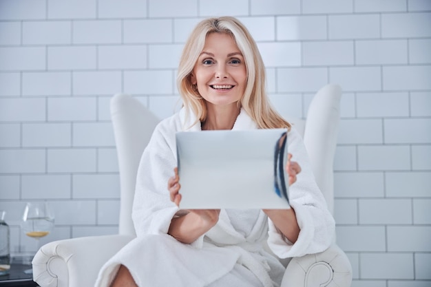 Heureuse femme joyeuse regardant et posant devant l'appareil photo dans le centre de bien-être