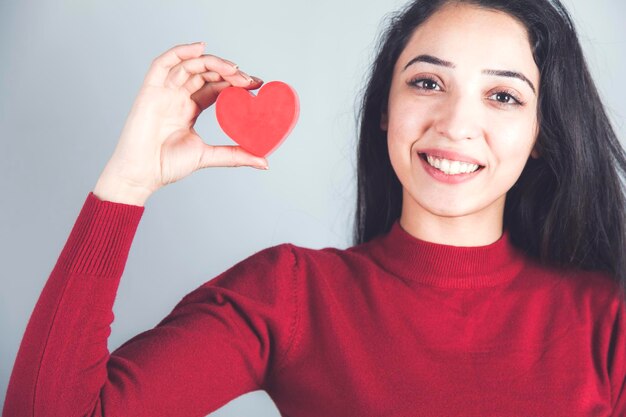 Heureuse femme main coeur rouge