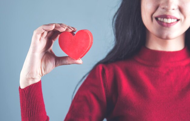 Heureuse femme main coeur rouge