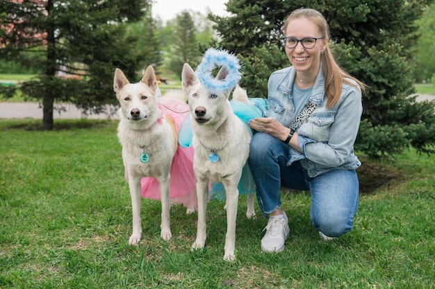 Heureuse femme marchant avec deux chiens can de palleiro dans le parc