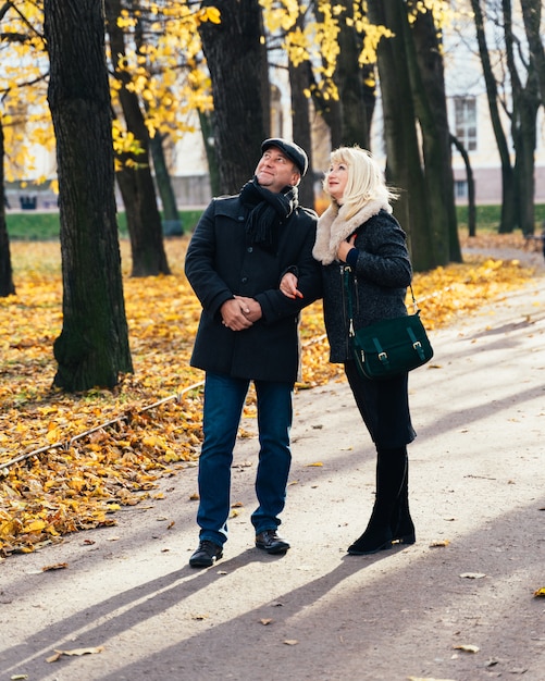 Heureuse femme mature blonde et belle brune d'âge moyen, levez les yeux vers le ciel, marche dans le parc