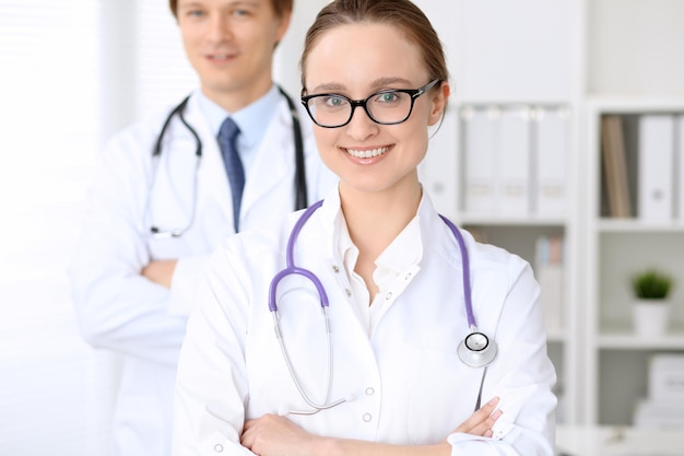 Heureuse femme médecin avec du personnel médical à l'hôpital