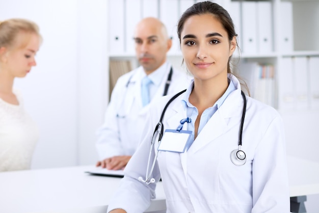 Heureuse femme médecin avec du personnel médical à l'hôpital